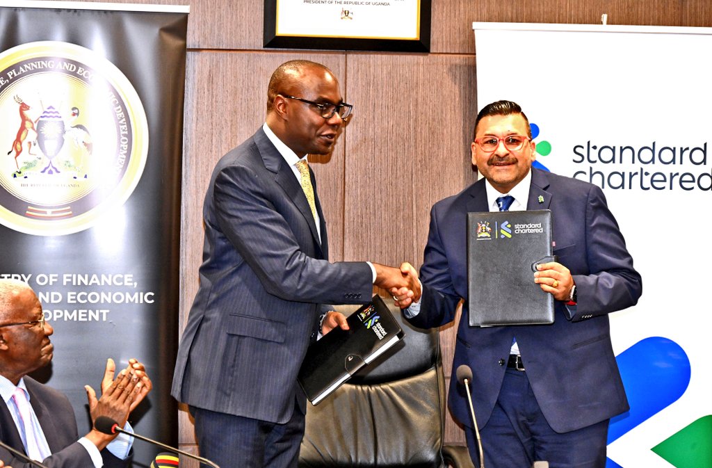 Finance Minister Henry Musasizi and Standard Chartered Bank Uganda CEO Sanjay Rughani exchange signed financing agreements for the €110.5 million Kitgum–Kidepo Road project in Kampala.